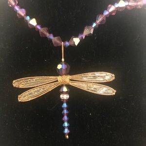 A crystal and gold tone dragonfly necklace.